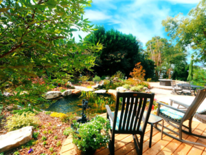 Tranquil backyard oasis with pond and patio seating.