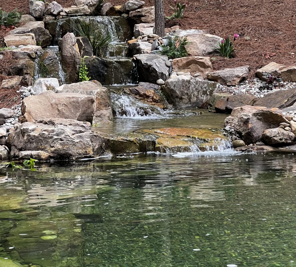 Small waterfall flowing into a serene pond